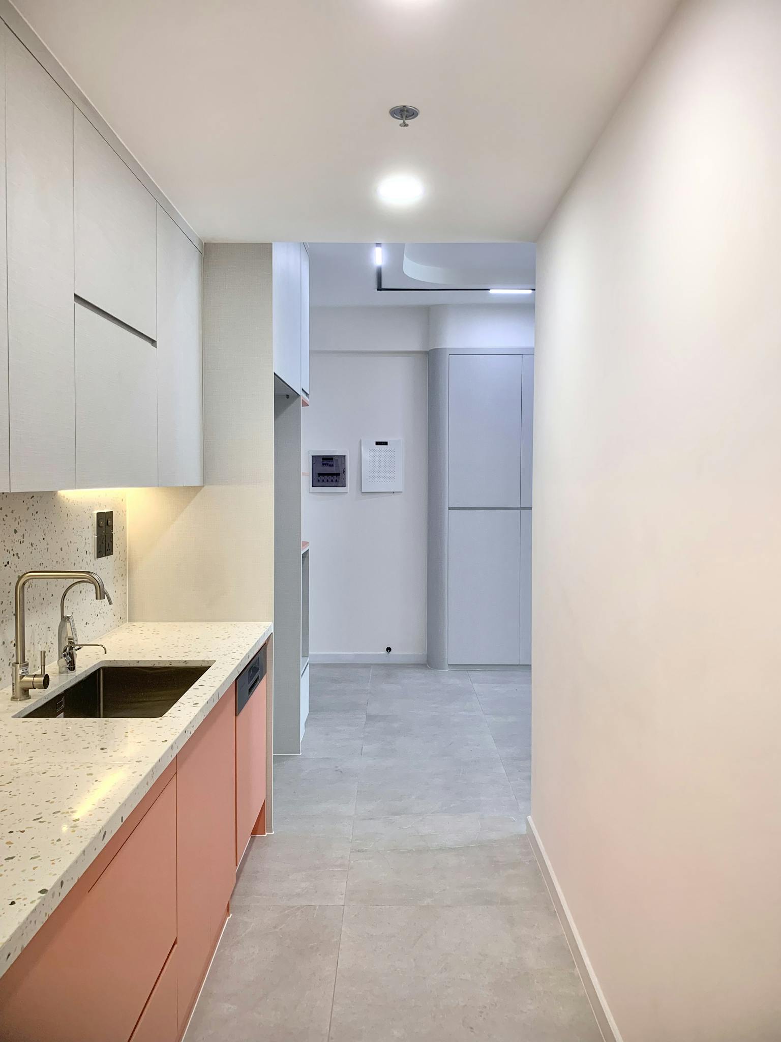 A sleek and modern minimalist kitchen with integrated cabinets and soft lighting.